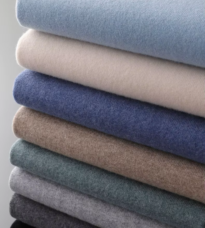 Stack of folded soft knit mock neck jumpers – colour range