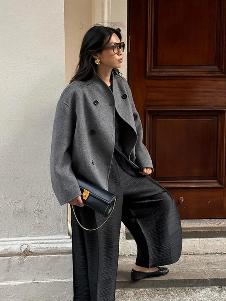 Women's short coat Yolande in Grey – side view by a doorway